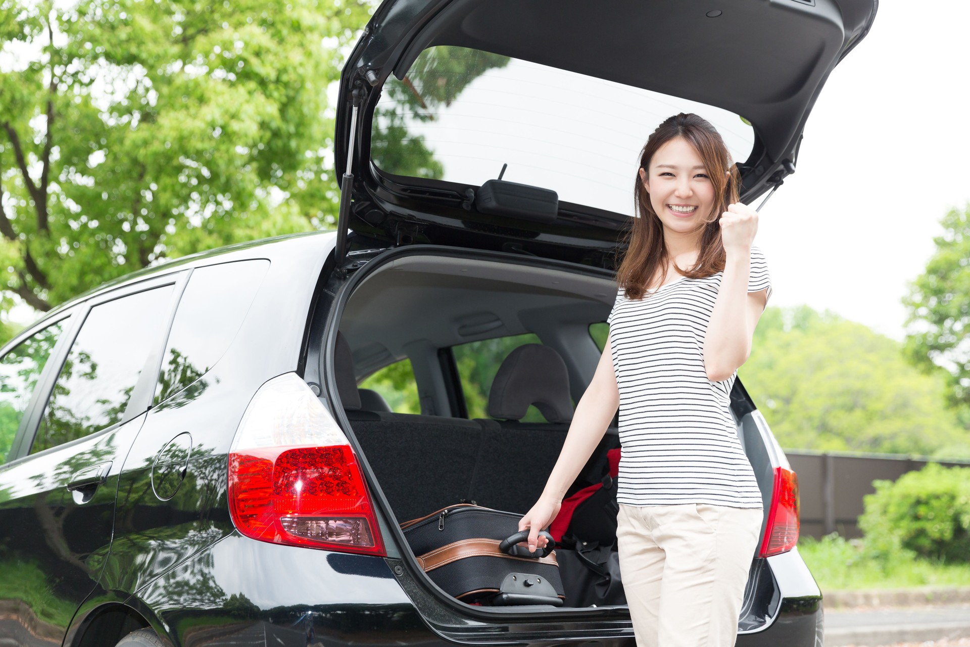 Woman standing next to a car boot