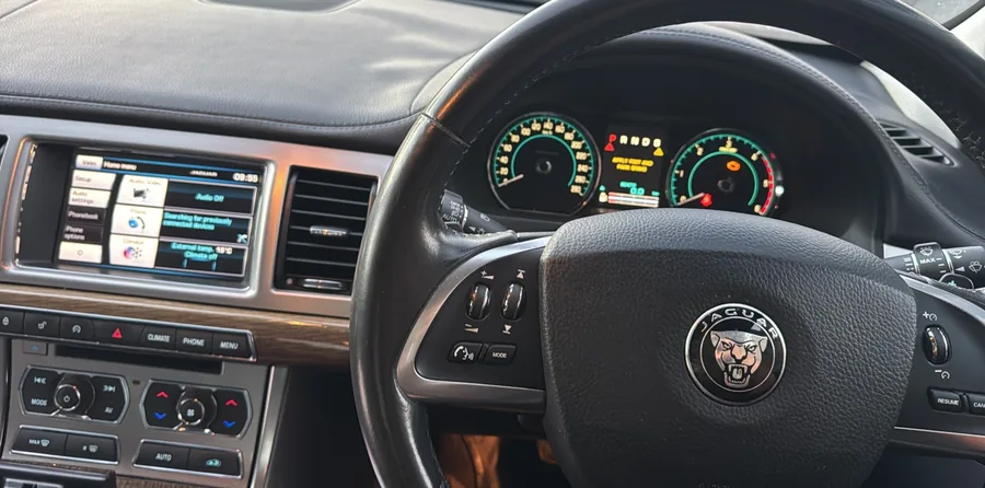 Jaguar XF dashboard with warnings on the instrument cluster and the touchscreen on the home menu