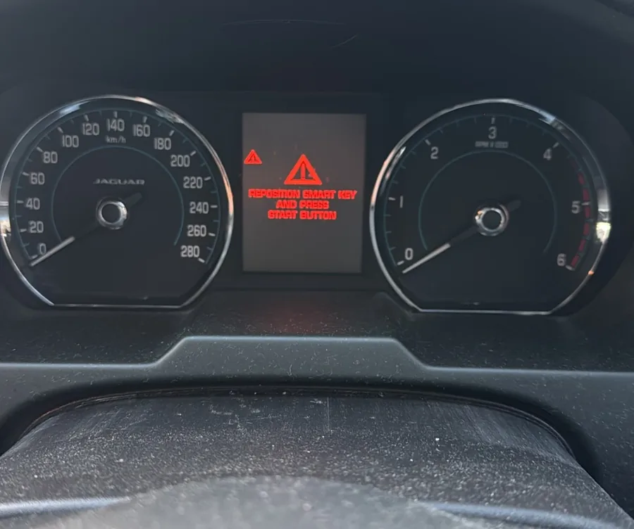 Jaguar XF instrument cluster showing the red warning Reposition smart key and press start button