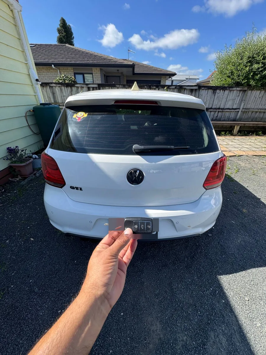 White VW Polo GTI from behind with the new flip key held up
