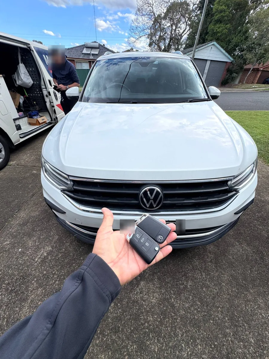White 2021 VW Tiguan from the front with two VW keys held up